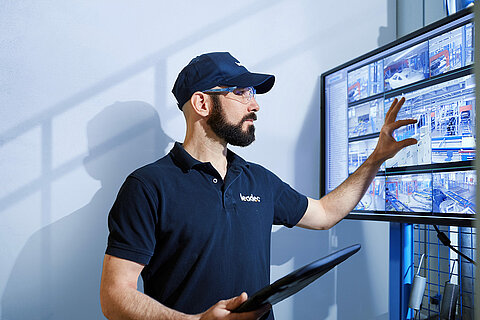 A Leadec employee in front of a screen monitoring the condition of a factory.