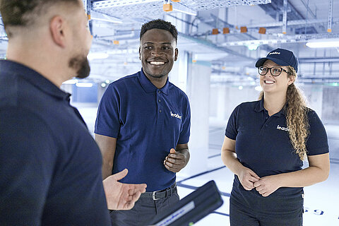 Leadec team talking in factory.